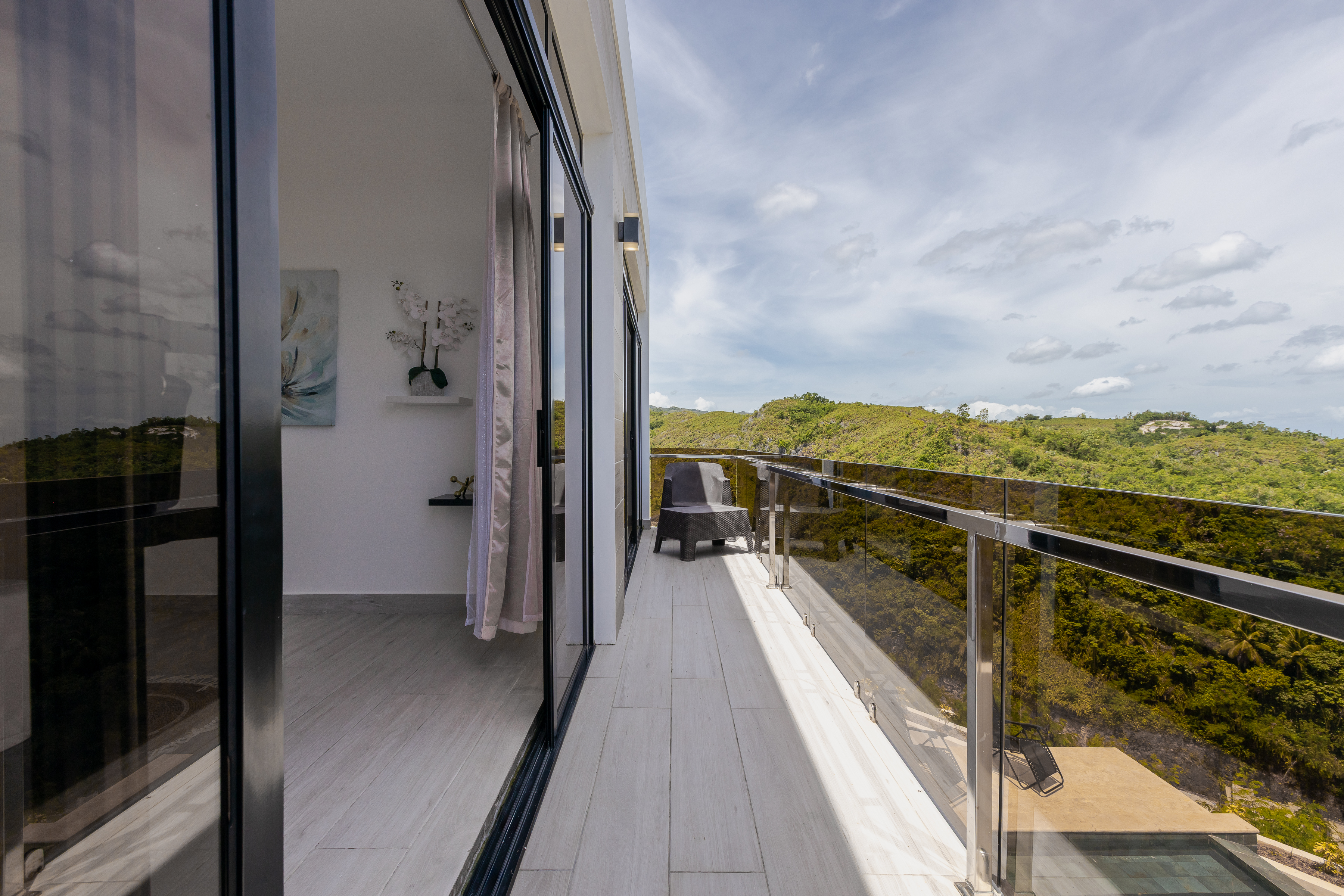 Private balcony with glass railing and Samaná mountain views